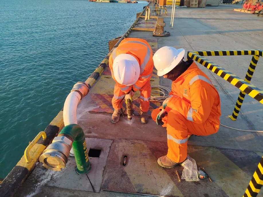 Crew working on an offshore deck during a fluid transfer operation