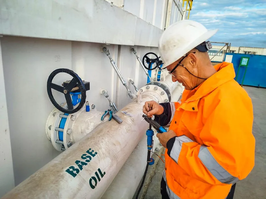 Technician operating a base oil transfer valve