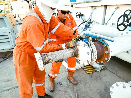 Engineer fitting a large valve assembly on site
