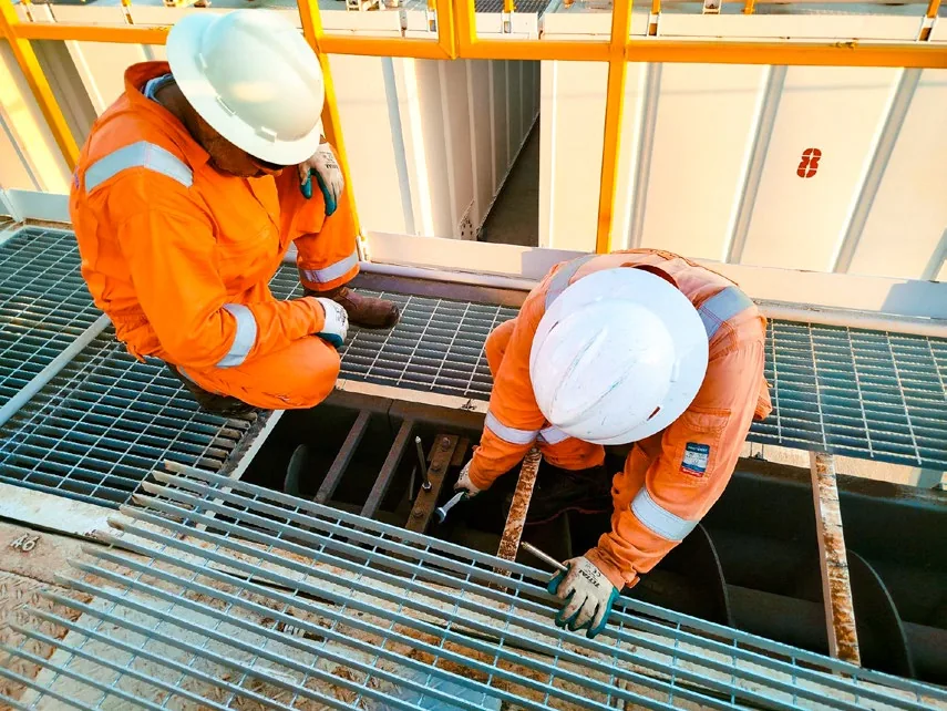 Technician installing deck grating at the plant